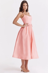 Detailed side view of a pink midi A-line dress with thin straps and a tailored waistline