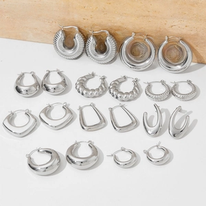 Close-up of assorted silver stainless steel hoop earrings with textured and smooth finishes