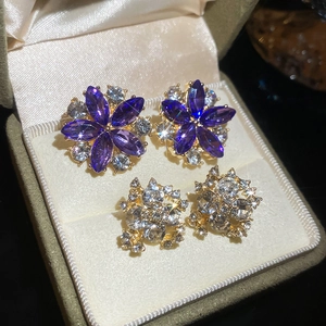 Macro shot of elegant silver needle flower earrings with purple and white crystals