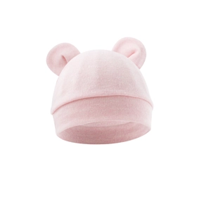 Close-up of soft pink baby knit hat with cute bear ears on white background