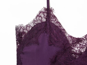 Dettaglio di pizzo delicato e cuciture in seta su canotta viola scuro