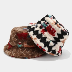 Detail view of two plush winter bucket hats with heart and geometric patterns in soft faux fur