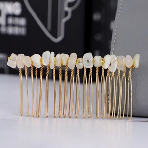 Dettaglio ravvicinato di un pettine per capelli in filo dorato con pietre di cristallo bianco
