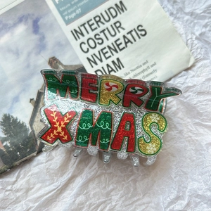Detail of Christmas claw clip with Merry Xmas lettering and sparkling glitter finish
