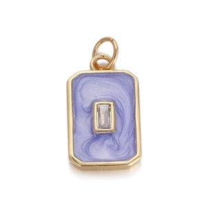 Close-up of golden rectangular pendant with purple enamel swirl and clear gemstone