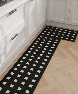 Detailed view of black and white checkerboard kitchen mats on a modern wood floor