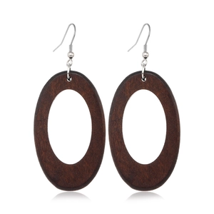 Detail shot of vintage brown oval wood earrings with natural grain and silver metal hooks