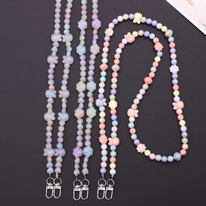 Pastel beaded phone straps with cat paw and rabbit charms on black background