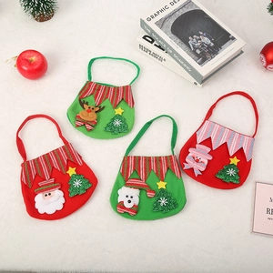 Détail de sacs cadeaux en feutre de Noël avec motifs Père Noël et renne sur fourrure