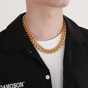 Close-up of a gold-toned Cuban link chain necklace worn on a male model neck