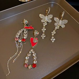 Detail of silver butterfly earrings with rhinestones and long tassel heart pendants