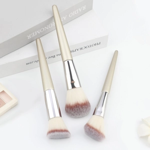 Detailed view of champagne gold makeup brushes with soft dual-tone fibers and silver ferrule