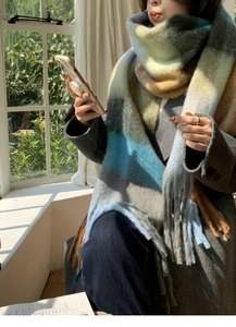 Macro detail of sky blue and mustard yellow thick wool scarf with long tassel fringe edge