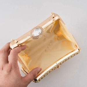 Golden evening clutch bag with rhinestones and satin lining shown in open view