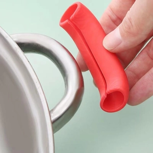 Installing red heat-resistant silicone pot handle cover on a stainless steel pot ear
