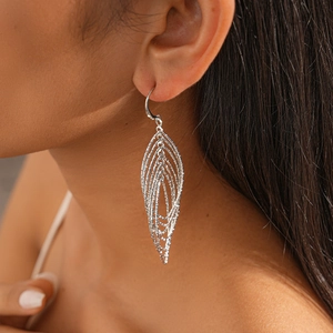 Macro view of silver layered leaf hollow drop earrings featuring fine metallic textures