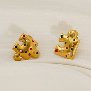 Close-up of gold-plated puzzle earrings with multi-colored crystals on fabric