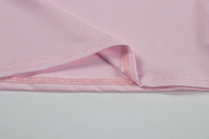 Macro shot of precise double-needle stitching on pink V-neck top's hemline detail