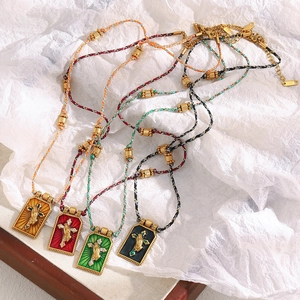 Detailed view of four hand-woven cross necklaces with colorful enamel on 18K gold plating
