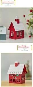 Detail of red metal Christmas house candle holder with snowy roof and festive hollow design