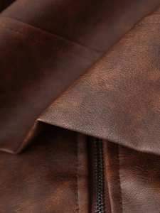 Vue détaillée de la texture du cuir vintage marron foncé et de la fermeture éclair en métal