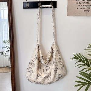 Detail of canvas shoulder bag with butterfly prints and trendy frayed edge texture