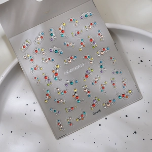 Macro shot of 3D crystal nail art stickers with silver relief and colorful rhinestones