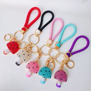 Detail view of colorful mushroom keychains with sparkling rhinestones and woven straps