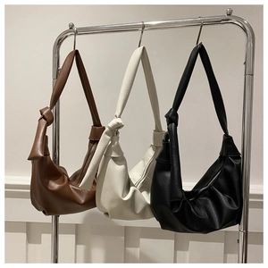 Three minimalist hobo bags in brown, beige, and black with textured lychee grain leather