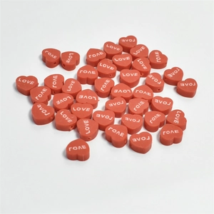 Macro shot of 10mm red heart beads with LOVE engraving for DIY jewelry making