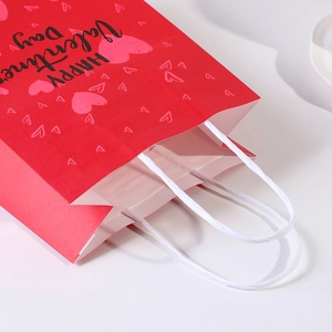 Red Valentine's Day paper gift bag with happy heart pattern and white rope handle