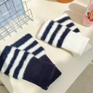 Close-up of black and white striped plush faux mink hand warmers with soft ribbed cuffs