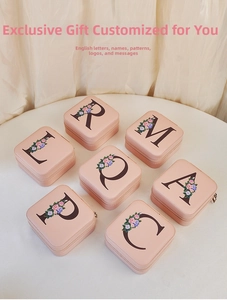 Flat lay of seven light pink PU leather jewelry boxes with floral letters and zippers
