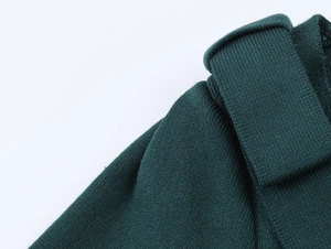Close-up of fine flat knit texture on a forest green shoulder bow cardigan sweater