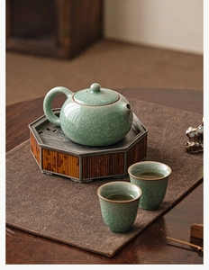 Detailed view of Ru Kiln celadon tea set with ice crackle glaze on a rustic wood tray