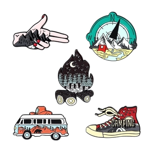 Set of five colorful enamel camping pins including compass mountain and hiking shoe designs