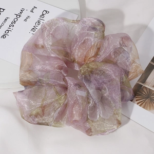 Detail of oversized pink-purple organza scrunchie with sparkling metallic golden texture