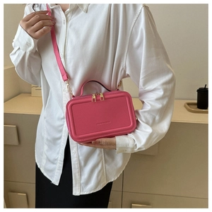 Close-up of stylish pink rectangular handbag with golden double zippers and fashion branding