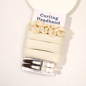 Macro shot of beige heatless curling headband with hair clips on paper packaging