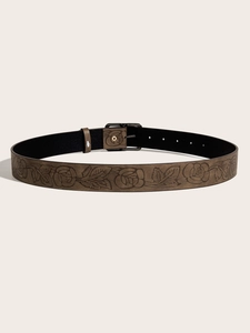 Close-up of brown rose embossed leather belt with dark metal buckle and black lining