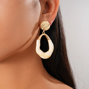 Close-up of model wearing geometric resin drop earring with gold metal stud