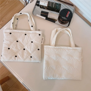 Dettaglio della borsa trapuntata bianca con pois e texture ricamate a onde