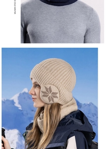 Detailed knit texture of beige winter beanie and scarf set with snowflake ear protection