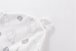 Detail of newborn cotton baby hat with cute bear print and soft knitted texture