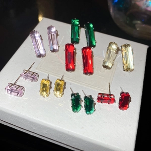 Macro view showing rectangular zircon earrings in pink, green, red, and yellow colors