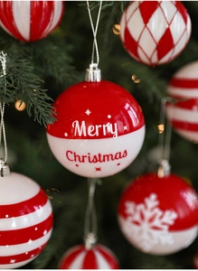 Gros plan d'une boule de Noël rouge et blanche avec texte et lumières festives