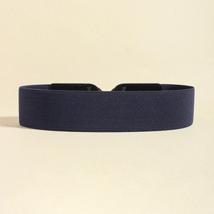 Close-up of dark blue wide elastic belt showing stretch weave texture and leather trim