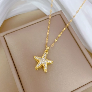 Macro shot of gold starfish pendant with cubic zirconia and shimmering chain detail
