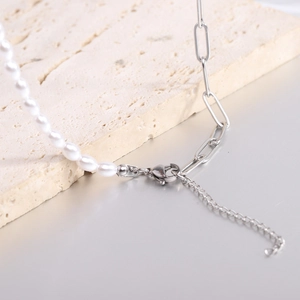 Detail of silver paperclip chain mixed with white pearls and adjustable lobster clasp