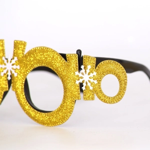 Detail of gold glitter Christmas party glasses with white snowflake decorative elements